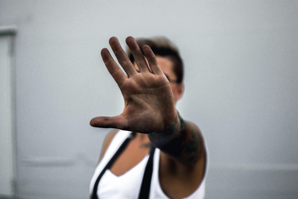 pexels-photo-1325619-1325619 Close-up of a person's hand raised in a stop gesture, against a neutral background.